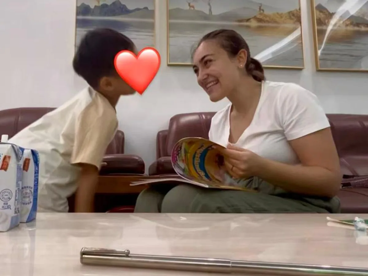 Una partecipante legge un libro con il bambino della famiglia ospitante