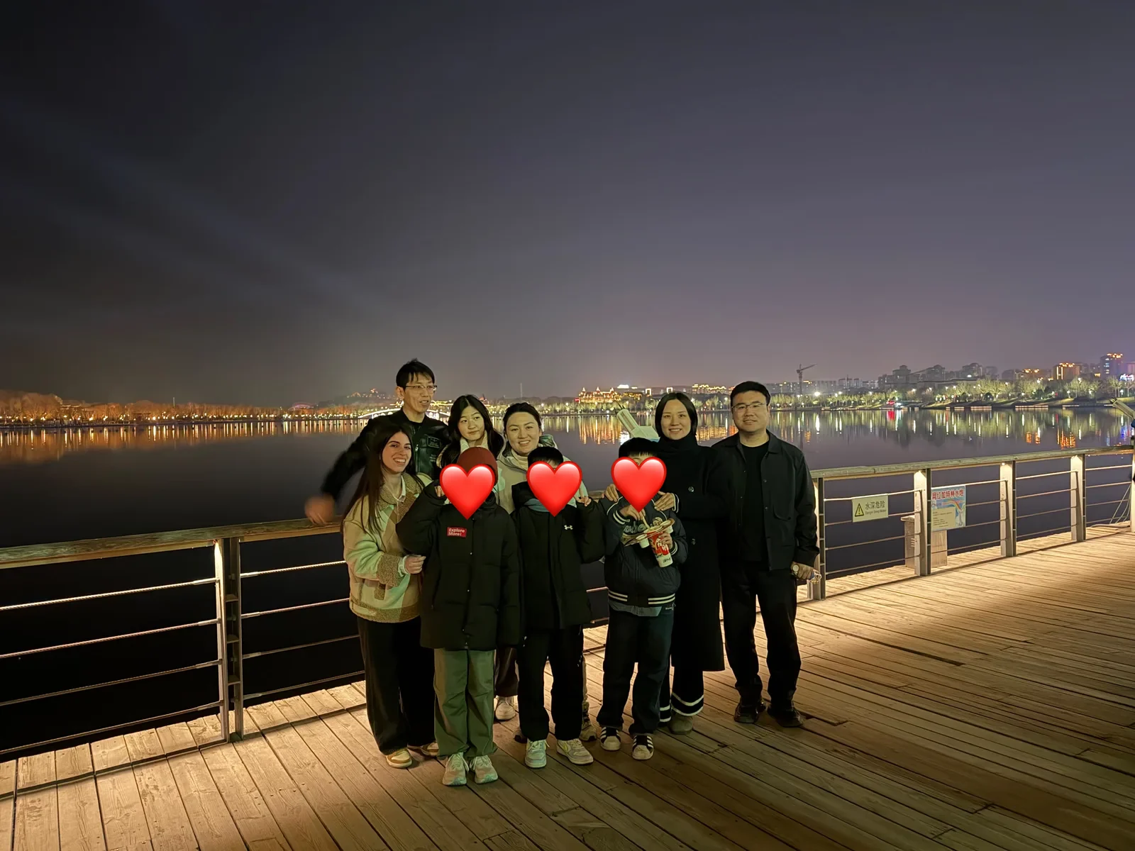 Vera con la famiglia ospitante sul lungofiume, di sera